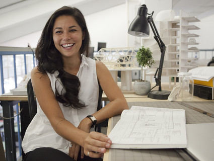 A female student sitting at a desk smiling