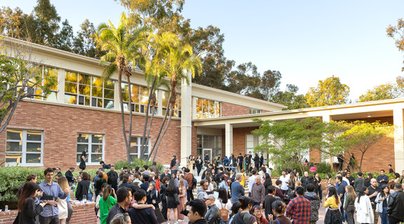 Exterior shot of Perloff Hall, a red brick building surrounded by trees