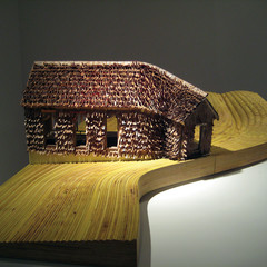 Image of Raspberry Fields, a model of a house on a yellow wooden base with brown curled cedar shingles.