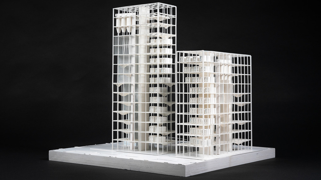 Model of a white high rise building against a black background