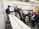 Jurors gather around a model of Green New Wave by Haoyu Chen, Liyao Chen, Kenny Wong, Siqi Zhang